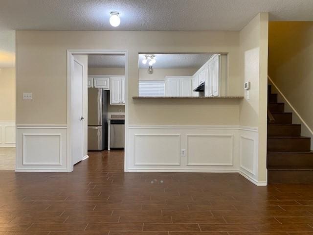 1404 Ranchview Ct, Carrollton, TX 75007 - interior space with dark wood-style floors, a decorative wall, wainscoting, stairway, and a textured ceiling