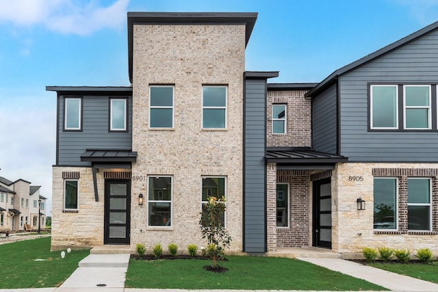 8901 Lowell St, Rowlett, TX 75089 - view of front of home featuring a standing seam roof, stone siding, metal roof, and a front lawn