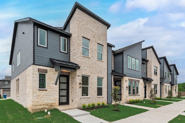 8901 Lowell St, Rowlett, TX 75089 - townhome / multi-family property with stone siding, a front yard, a standing seam roof, metal roof, and a residential view