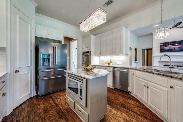 2841 Winding Creek Rd, Prosper, TX 75078 - kitchen with stainless steel appliances, a chandelier, a sink, crown molding, and white cabinets