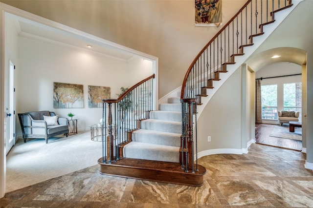 2841 Winding Creek Rd, Prosper, TX 75078 - stairway with a towering ceiling, baseboards, arched walkways, stone finish flooring, and crown molding
