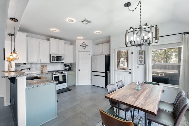 135 Pine Island Ln, Leander, TX 78641 - dining area with a chandelier, light tile patterned floors, and baseboards
