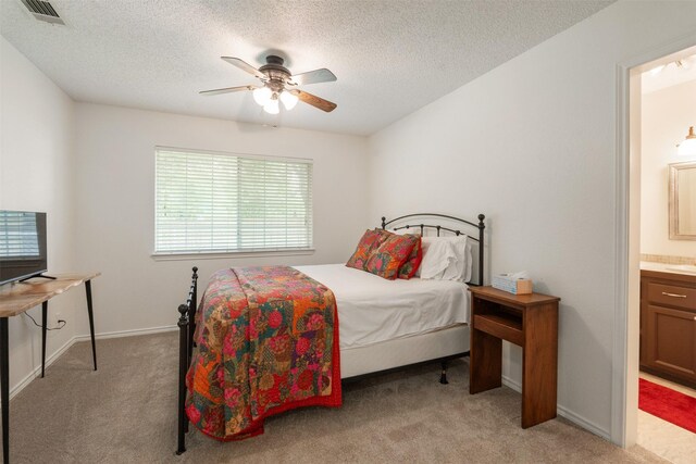 12752 Honeysuckle Cir, Eustace, TX 75124 - bedroom featuring light colored carpet, multiple windows, a textured ceiling, ensuite bath, and ceiling fan