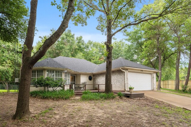 12752 Honeysuckle Cir, Eustace, TX 75124 - ranch-style house featuring an attached garage, driveway, brick siding, a shingled roof, and a wooden deck