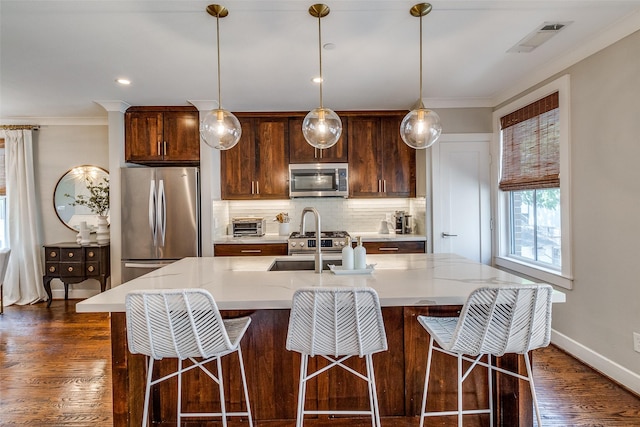 4121 Grassmere Ln Unit 3, University Park, TX 75205 - kitchen featuring appliances with stainless steel finishes, tasteful backsplash, a sink, an island with sink, and dark wood-style floors