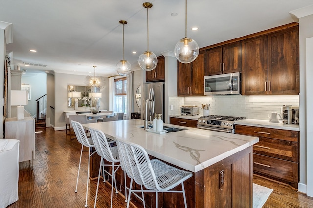 4121 Grassmere Ln Unit 3, University Park, TX 75205 - kitchen with appliances with stainless steel finishes, a sink, an island with sink, a kitchen bar, and backsplash