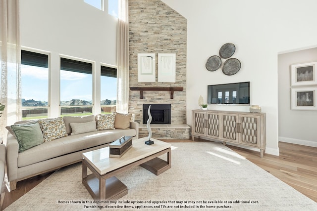 411 Atlas Cedar Dr, Glenn Heights, TX 75154 - living room featuring a towering ceiling, wood finished floors, a stone fireplace, and baseboards