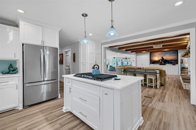 1016 Crestview Dr, Sherman, TX 75092 - kitchen featuring appliances with stainless steel finishes, crown molding, light wood-style flooring, white cabinetry, and hanging light fixtures