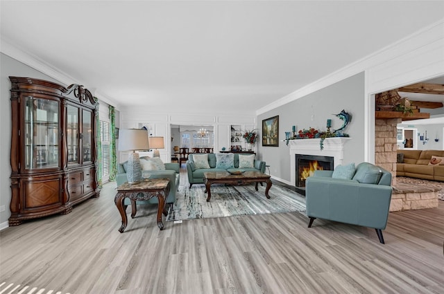 1016 Crestview Dr, Sherman, TX 75092 - living room featuring light wood-type flooring, crown molding, a warm lit fireplace, and a chandelier