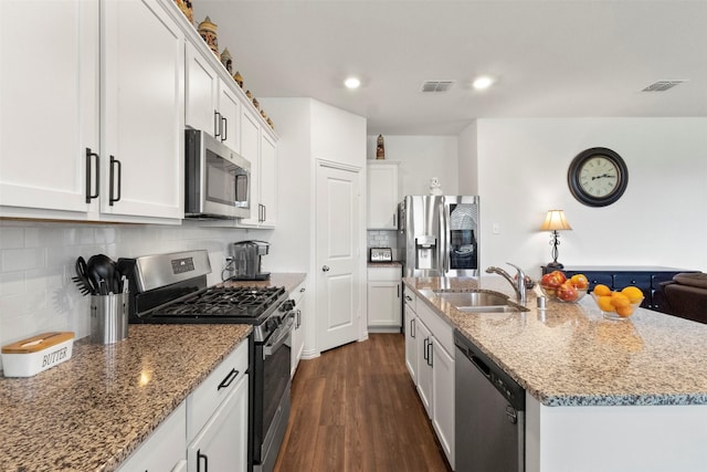 797 Hawthorn St, Princeton, TX 75407 - kitchen featuring stainless steel appliances, dark wood-type flooring, light stone counters, white cabinets, and an island with sink