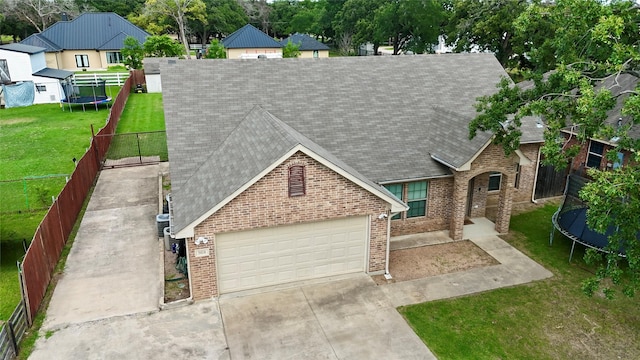 5414 Wild Oak Rd, Balch Springs, TX 75180 - view of front of house with a trampoline, roof with shingles, driveway, and brick siding