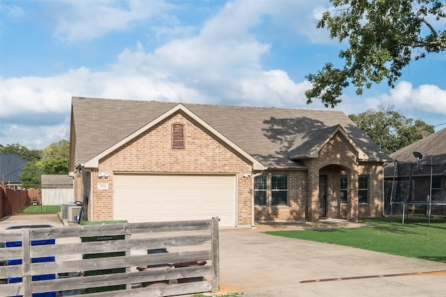 5414 Wild Oak Rd, Balch Springs, TX 75180 - view of front of home with a trampoline, driveway, brick siding, and a garage