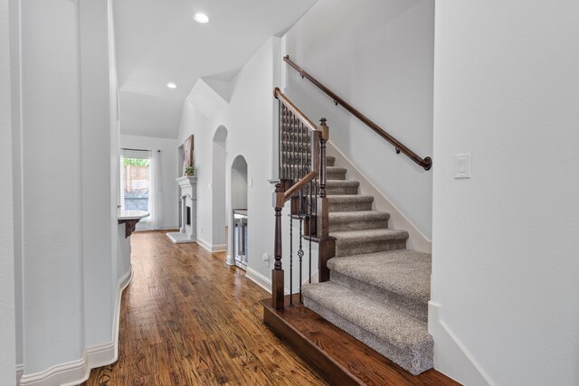 1208 Claire St, Lantana, TX 76226 - entrance foyer featuring wood finished floors, stairs, a fireplace with raised hearth, vaulted ceiling, and recessed lighting
