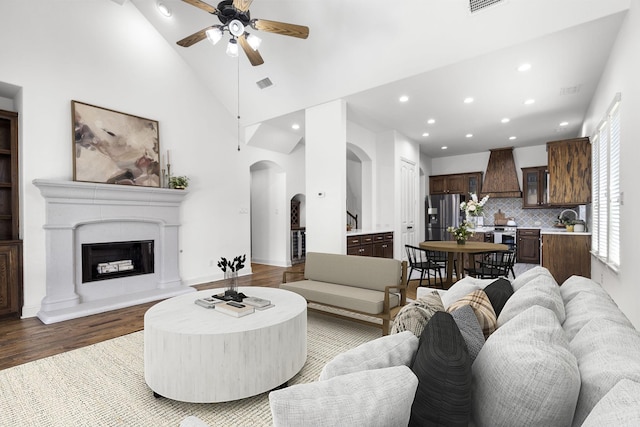 1208 Claire St, Lantana, TX 76226 - living room featuring arched walkways, recessed lighting, wood finished floors, ceiling fan, and high vaulted ceiling