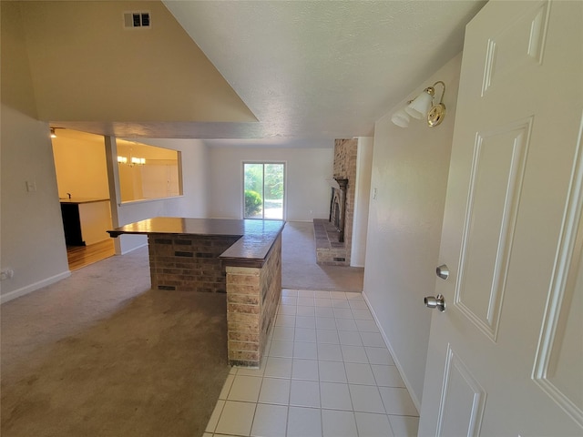 1340 Finley Dr, Plano, TX 75025 - kitchen featuring light colored carpet, a chandelier, a brick fireplace, baseboards, and light tile patterned floors