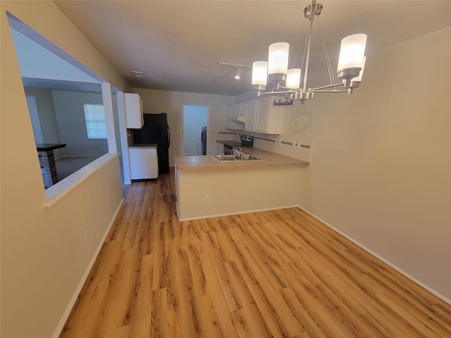 1340 Finley Dr, Plano, TX 75025 - kitchen with white cabinets, a chandelier, light wood-style floors, light countertops, and a peninsula