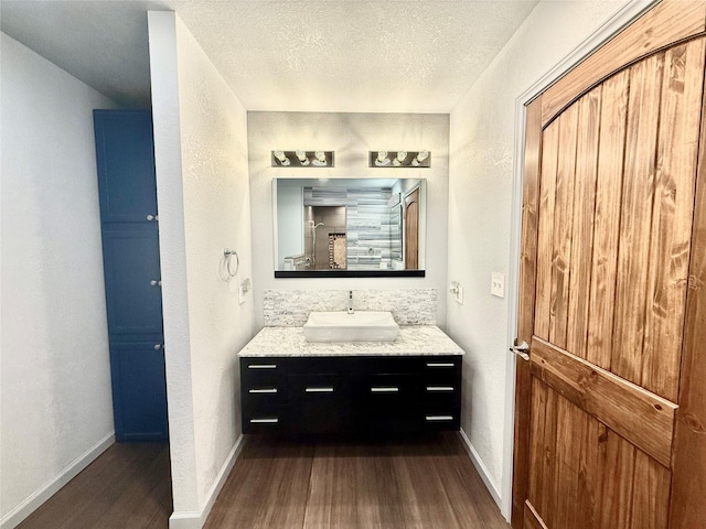 1415 Scenic Dr, Graham, TX 76450 - bathroom featuring wood finished floors, vanity, a textured ceiling, and baseboards