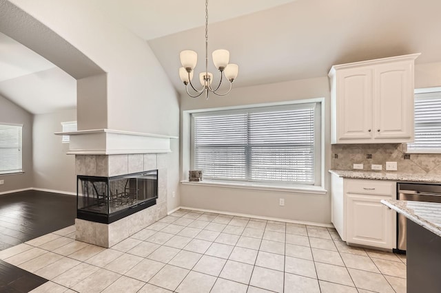 2124 Leonard Ranch Rd, Fort Worth, TX 76134 - kitchen featuring lofted ceiling, white cabinets, a tiled fireplace, and healthy amount of natural light