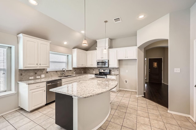 2124 Leonard Ranch Rd, Fort Worth, TX 76134 - kitchen with stainless steel appliances, a sink, backsplash, arched walkways, and white cabinetry