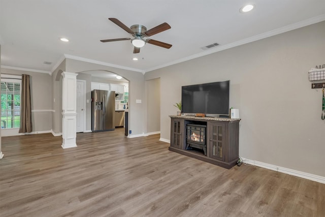 203 Olive St, Waxahachie, TX 75165 - unfurnished living room with ceiling fan, light wood-type flooring, recessed lighting, ornate columns, and arched walkways