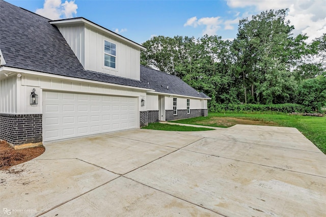 231 Ramsey, Stonewall, LA 71078 - view of side of property with brick siding, board and batten siding, concrete driveway, and a yard