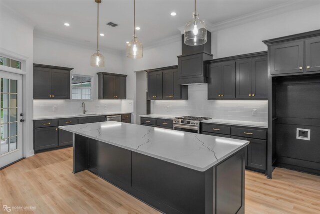 231 Ramsey, Stonewall, LA 71078 - kitchen featuring decorative backsplash, crown molding, appliances with stainless steel finishes, a center island, and light stone countertops