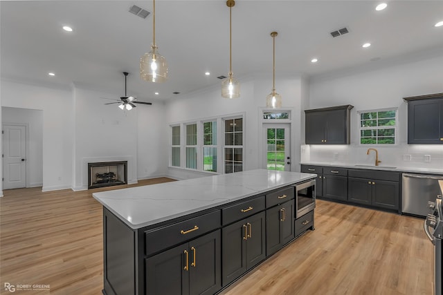 231 Ramsey, Stonewall, LA 71078 - kitchen with appliances with stainless steel finishes, a center island, light wood finished floors, a ceiling fan, and pendant lighting