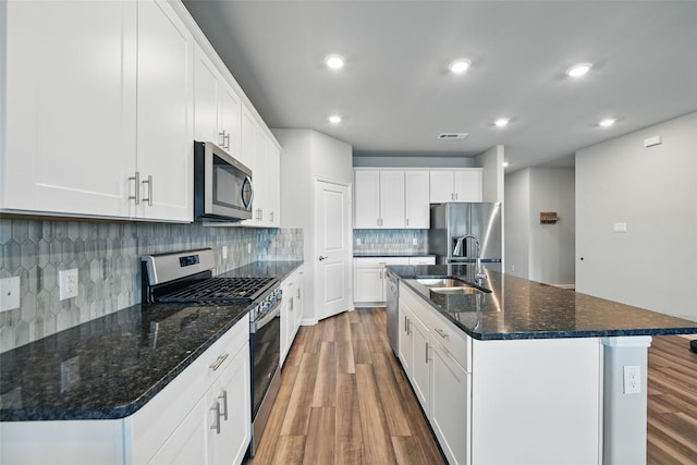 5637 Castle Peak Bnd, Fort Worth, TX 76126 - kitchen with stainless steel appliances, a sink, wood finished floors, backsplash, and an island with sink