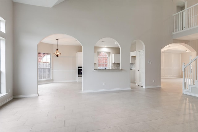 5312 Bellis Dr, Fort Worth, TX 76244 - unfurnished living room with a towering ceiling, stairway, a sink, and baseboards