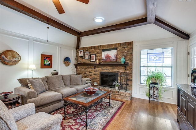 1520 Papeete Dr, Plano, TX 75075 - living area featuring a decorative wall, beamed ceiling, ceiling fan, light wood-style floors, and a brick fireplace