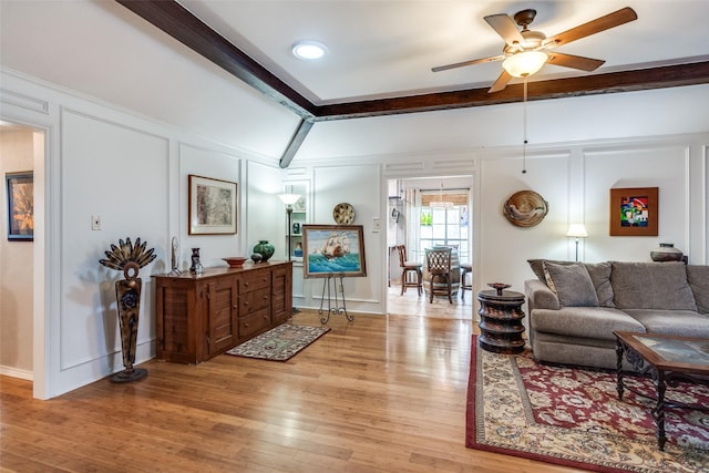 1520 Papeete Dr, Plano, TX 75075 - living room featuring a decorative wall, a ceiling fan, light wood-style floors, beamed ceiling, and baseboards