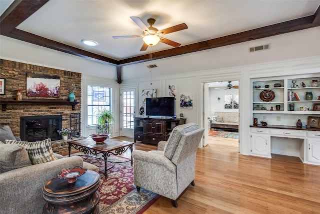1520 Papeete Dr, Plano, TX 75075 - living area with ceiling fan, light wood finished floors, a fireplace, beam ceiling, and an office area