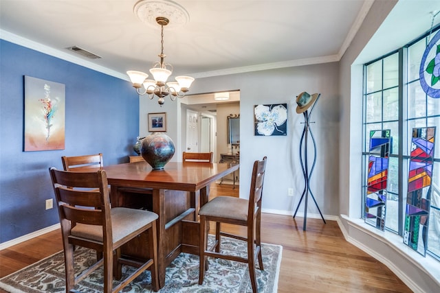 1520 Papeete Dr, Plano, TX 75075 - dining area with a chandelier, wood finished floors, ornamental molding, and baseboards