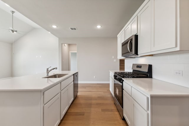 2745 Lopice Ln, Fort Worth, TX 76179 - kitchen featuring stainless steel appliances, a sink, a ceiling fan, backsplash, and light wood-style floors