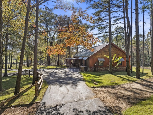 1057 Silver Lake Cir, Mount Pleasant, TX 75455 - rustic home featuring asphalt driveway, a front lawn, and metal roof