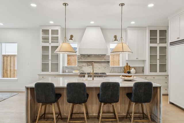 6244 Richmond Ave, Dallas, TX 75214 - kitchen with custom exhaust hood, paneled fridge, light wood-type flooring, backsplash, and recessed lighting
