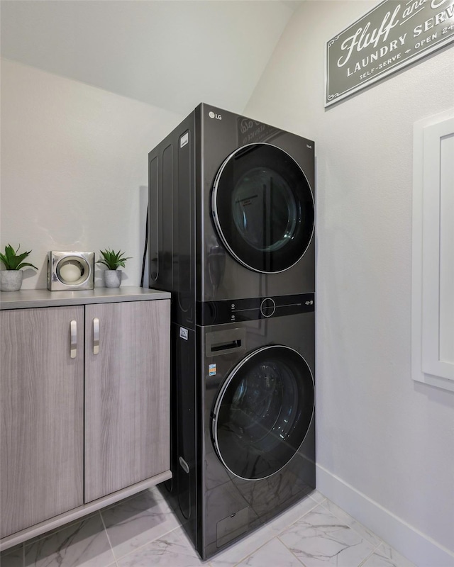 363 Somerville Dr, Mckinney, TX 75071 - washroom featuring stacked washer / drying machine, light marble finish flooring, cabinet space, and baseboards