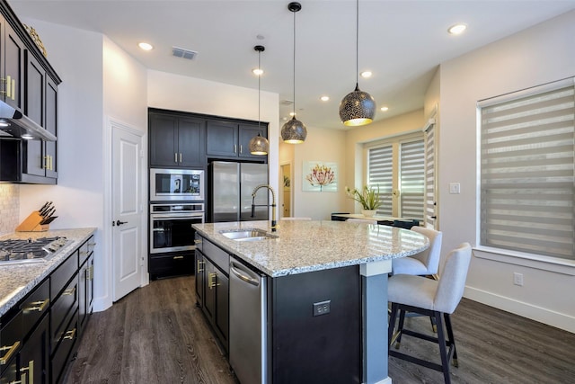 363 Somerville Dr, Mckinney, TX 75071 - kitchen with appliances with stainless steel finishes, a sink, dark wood finished floors, a breakfast bar area, and recessed lighting