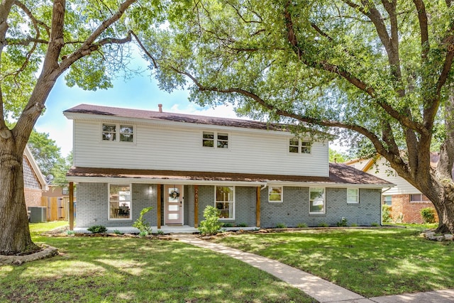2617 Beechmont Dr, Dallas, TX 75228 - traditional-style house with brick siding, a front yard, central AC unit, and a porch