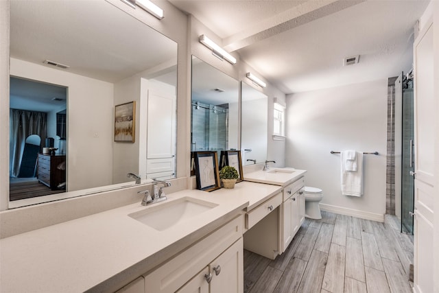 2617 Beechmont Dr, Dallas, TX 75228 - full bath with double vanity, wood tiled floors, baseboards, toilet, and an enclosed shower