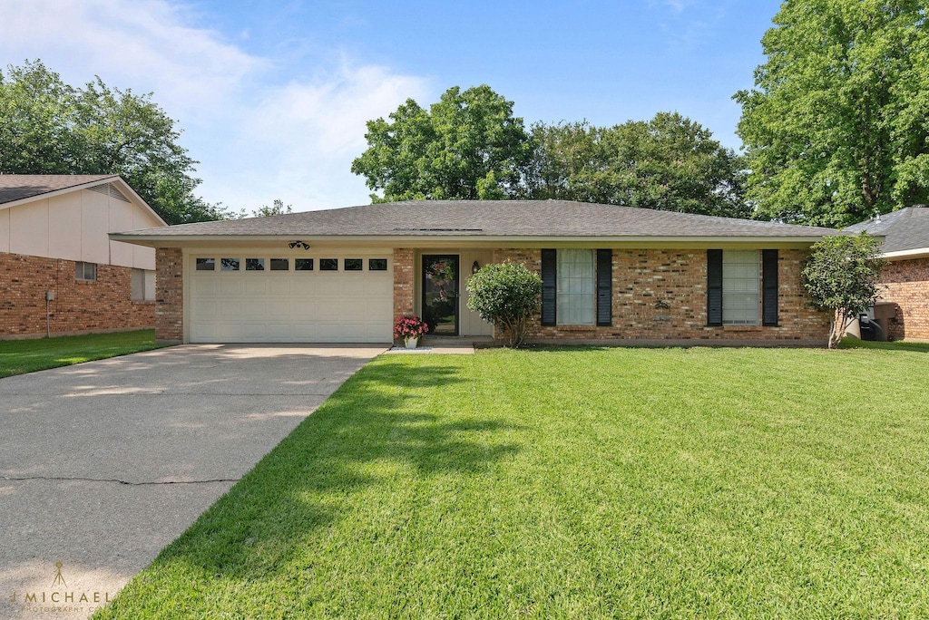 176 India Dr, Shreveport, LA 71115 - single story home with an attached garage, driveway, a front lawn, and brick siding