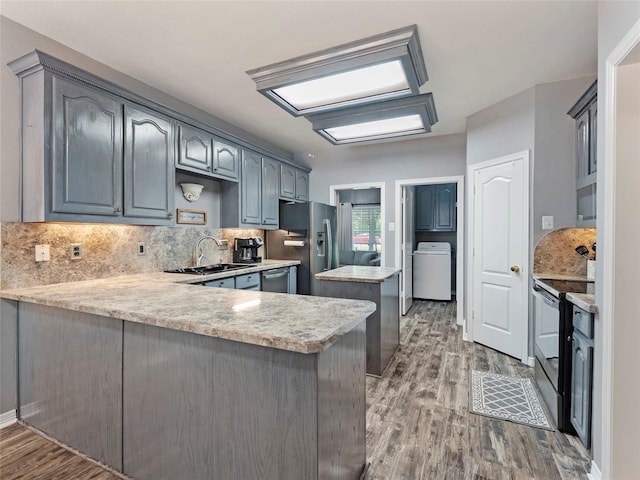 4710 Ashley Cir, Midlothian, TX 76065 - kitchen featuring stainless steel appliances, washer / clothes dryer, a peninsula, and wood finished floors