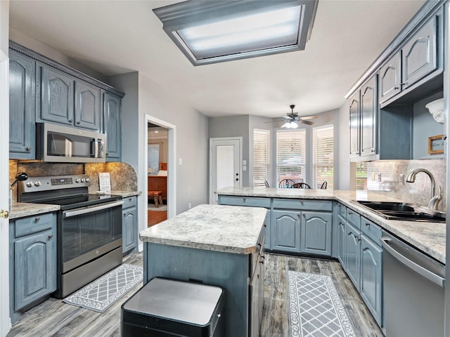 4710 Ashley Cir, Midlothian, TX 76065 - kitchen with appliances with stainless steel finishes, light wood-style floors, a peninsula, and decorative backsplash