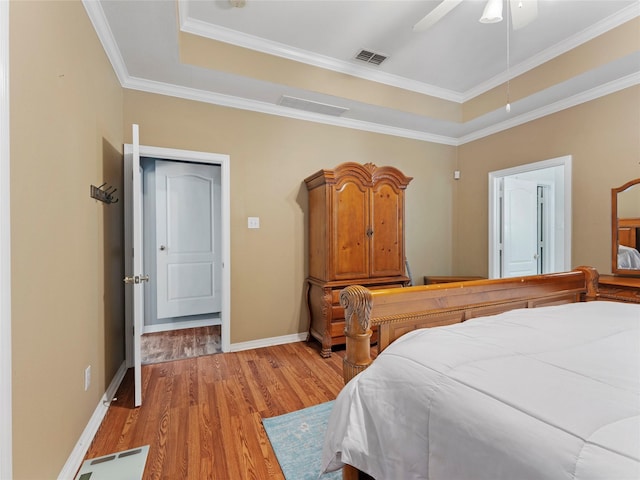 4710 Ashley Cir, Midlothian, TX 76065 - bedroom featuring a tray ceiling, light wood-type flooring, ornamental molding, and a ceiling fan