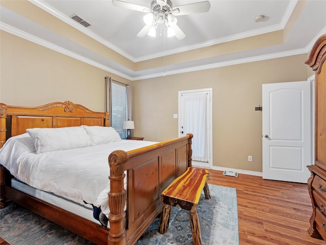 4710 Ashley Cir, Midlothian, TX 76065 - bedroom featuring a raised ceiling, wood finished floors, ornamental molding, and a ceiling fan