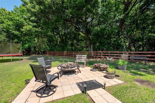 4710 Ashley Cir, Midlothian, TX 76065 - fenced backyard with a fire pit, a trampoline, and a patio