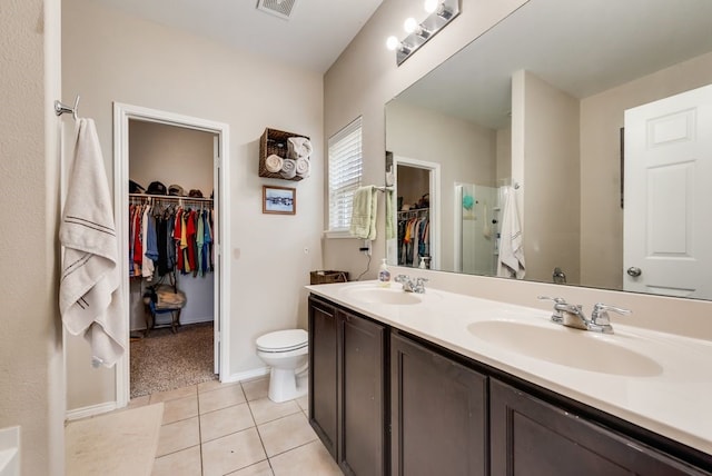 10237 Pyrite Dr, Fort Worth, TX 76131 - bathroom with a walk in closet, double vanity, toilet, tile patterned flooring, and baseboards