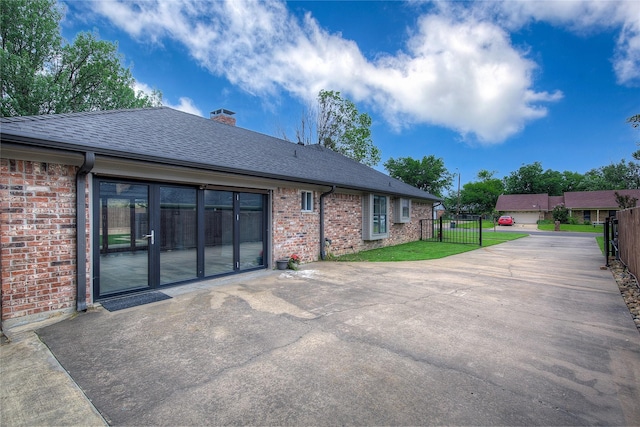 1220 Melony Dr, Sulphur Springs, TX 75482 - back of property with brick siding, a shingled roof, a chimney, and concrete driveway
