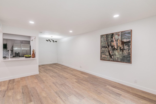 4851 Cedar Springs Rd Unit 175, Dallas, TX 75219 - unfurnished living room with light wood-style flooring, baseboards, recessed lighting, and a sink