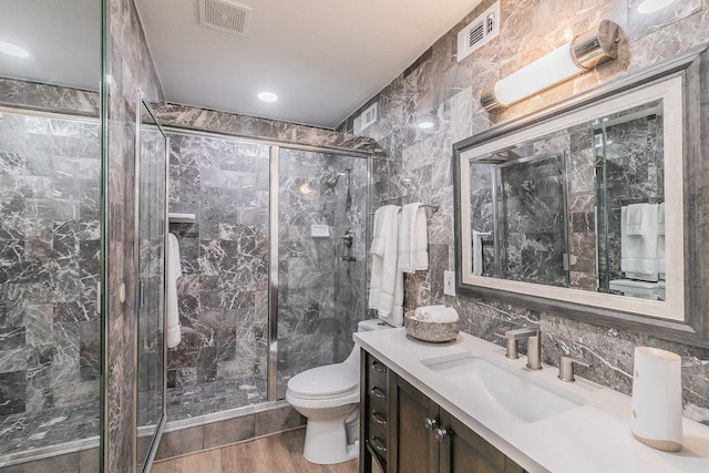 4851 Cedar Springs Rd Unit 175, Dallas, TX 75219 - bathroom featuring toilet, tile walls, a marble finish shower, vanity, and wood finished floors